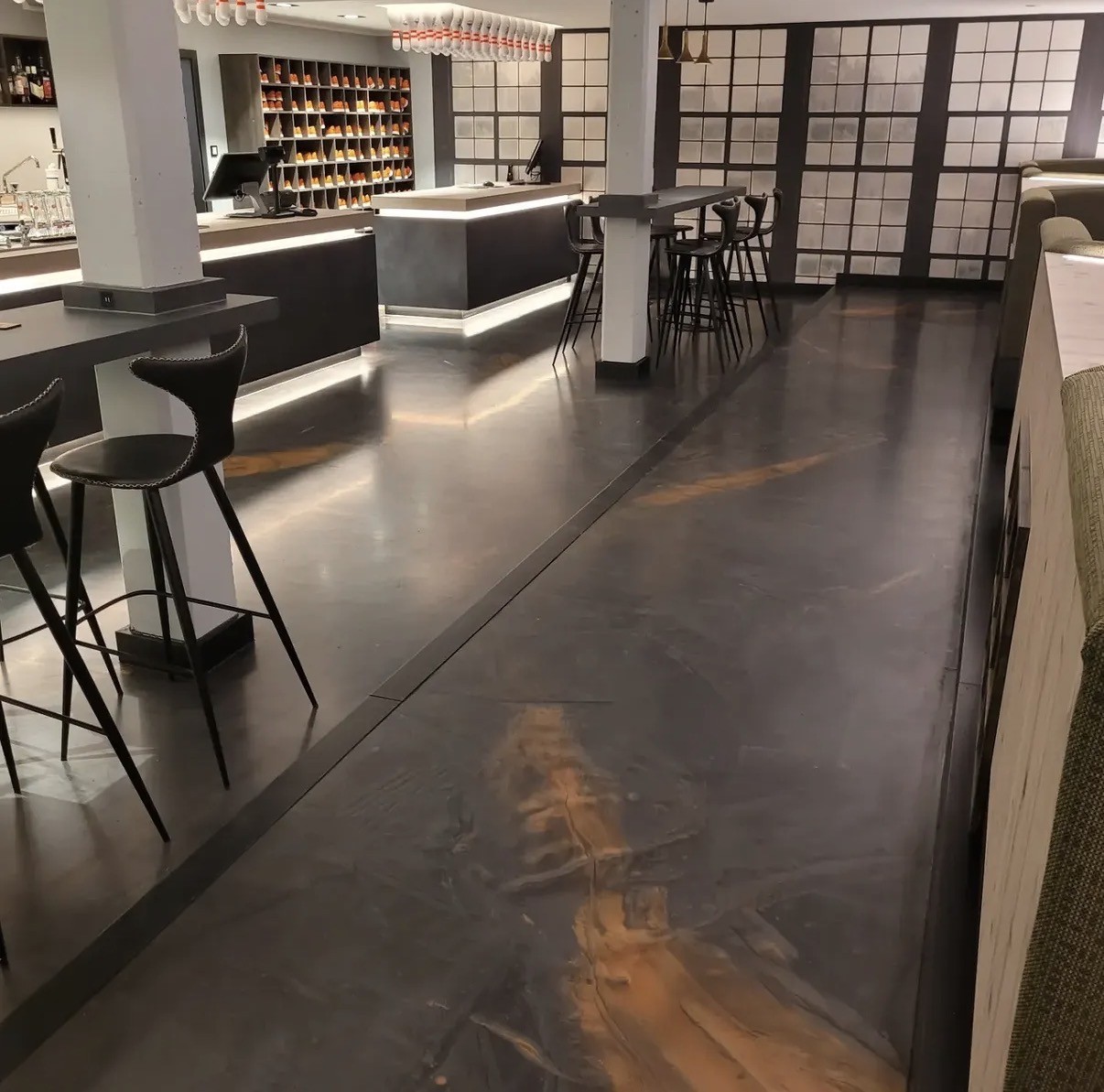 Metallic charcoal and copper epoxy floor in a bowling alley lounge
