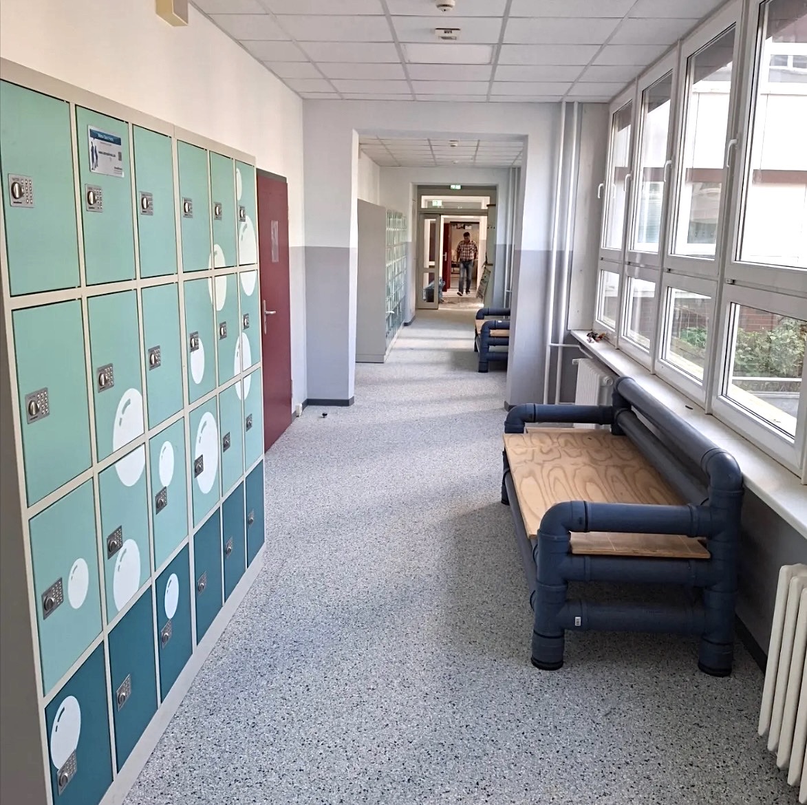 Durable speckled epoxy floor in a bright school hallway